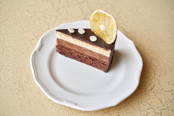 Chocolate sponge cake, with mousse, decorated with Orange slice and meringue. Breakfast in the cafe, morning coffee. on wooden table.