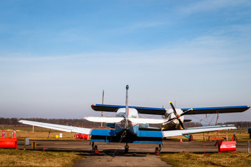 A small plane stands in the parking lot of an old airfield. Wings. Airport. Airfield. Flights by plane.
