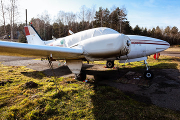 A small plane stands in the parking lot of an old airfield. Wings. Airport. Airfield. Flights by...