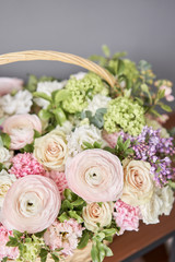 Flowers delivery. Flower arrangement in large Wicker basket. Beautiful bouquet of mixed flowers in woman hand. Floral shop concept . Handsome fresh bouquet.