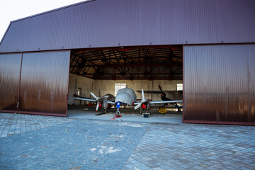 A small plane stands in the parking lot of an old airfield. Wings. Airport. Airfield. Flights by plane.