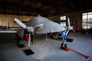 A small plane stands in the parking lot of an old airfield. Wings. Airport. Airfield. Flights by plane.