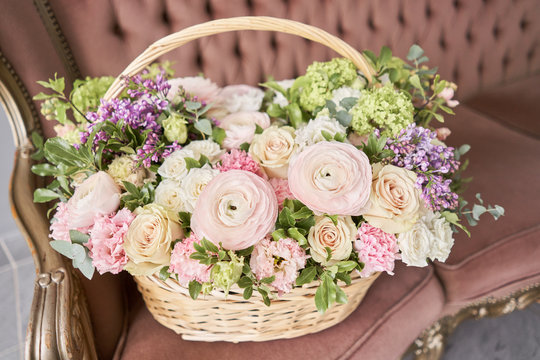 Flowers delivery. Flower arrangement in large Wicker basket. Beautiful bouquet of mixed flowers in woman hand. Floral shop concept . Handsome fresh bouquet.