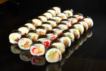 Various kinds of sushi roll set served on black stone. Japanese food