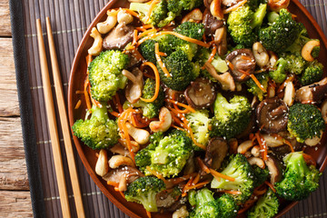 Healthy food shiitake mushrooms, broccoli, carrots and cashew nuts close-up in a plate. Horizontal top view