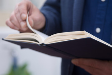 man turning the sheets of a book