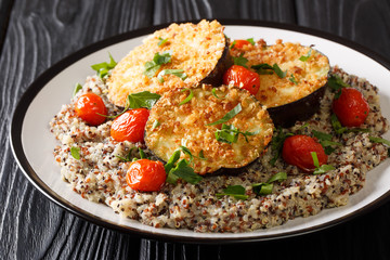 Healthy food baked eggplant served with boiled quinoa close-up on a plate. horizontal