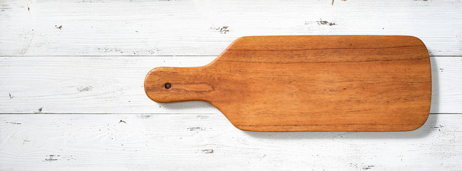 Handmade long wooden cutting board on white desktop.  Long wooden pallets on the table.