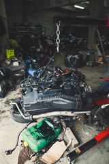 An auto mechanic working on a car engine in a mechanics garage. Repair service. Close-up, dark background