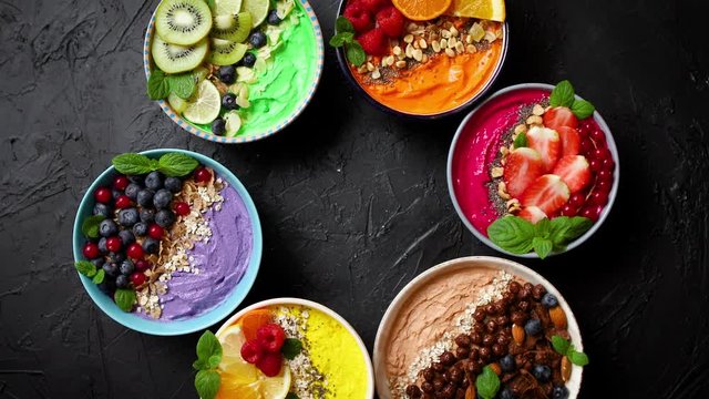 Various healthy fresh smoothies or yogurts in bowls. With strawberries, kiwi, chia, blackberries