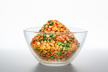 colorful dry chopped peas in a glass bowl light background