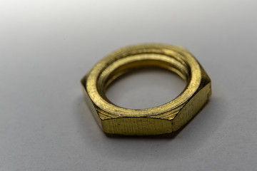 Close-up macro of gold hexagonal screw nut isolated on white background