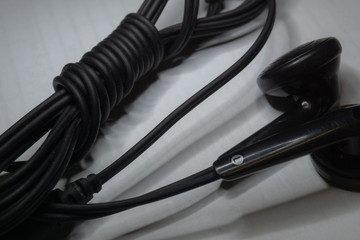 Black and white isolated close up of cable management for black with 3.5mm jack earphones