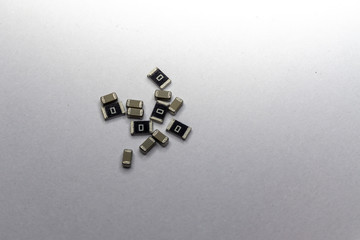 Abstract close-up scattered 0603 SMT MLCC capacitors, resistors electronics components white background random pattern