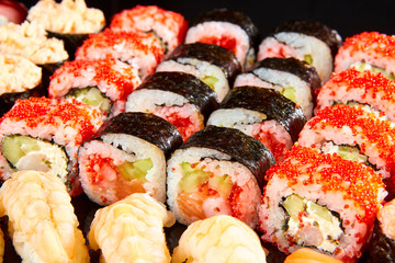 Various kinds of sushi roll set served on black stone. Japanese food