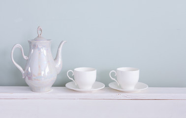 Set of tea cups and  ceramic teapot  on shelf