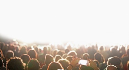 many heads of fan at concert and white stage