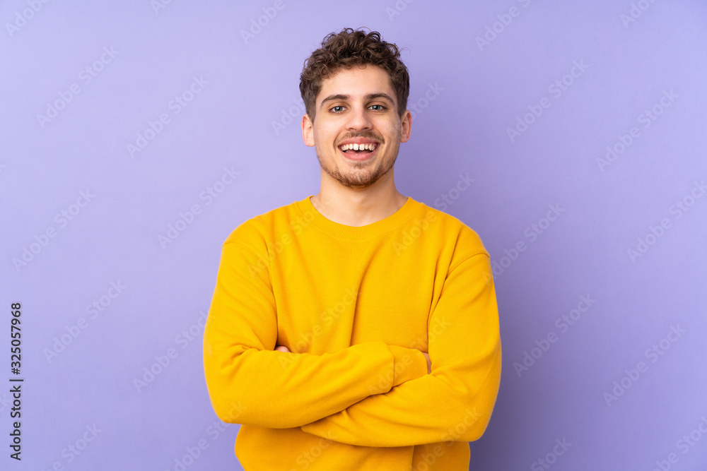 Wall mural Caucasian man isolated on purple background keeping the arms crossed in frontal position