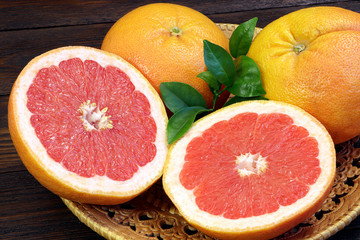 Grapefruit fruits on a wooden table. Healthy food. Brown background. Grapefruits on a tray.