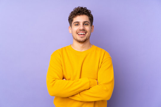 Caucasian man isolated on purple background keeping the arms crossed in frontal position