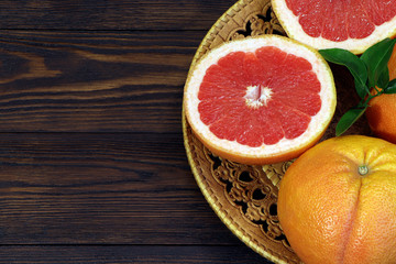 Fototapeta na wymiar Grapefruit fruits on a wooden table. Healthy food. Brown background. Grapefruits on a tray.
