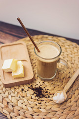 Keto bulletproof coffee in glass with metal straw with ingredients