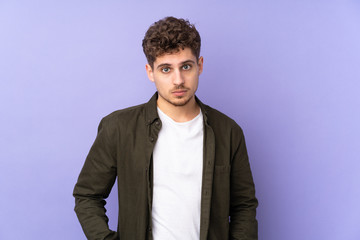 Fototapeta premium Caucasian man isolated on purple background with sad expression