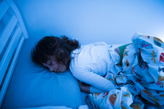 Small 11 Year Old Girl Sleeping In Bed On A Stomach.