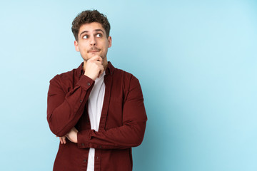 Young caucasian man isolated background having doubts and thinking