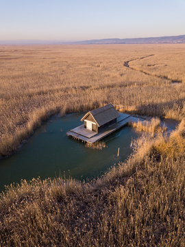 A small hut in a reed field in the middle of the Schilfg&uuml;rtel of Neusiedler See near Breitenbrunn in Burgenland Austria on a cold winter morning with frozen water