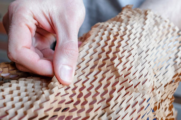 Examine the packaging. Touch the thin brown paper into the grid. New type of packaging