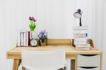 A wooden table for reading in a clean white room.