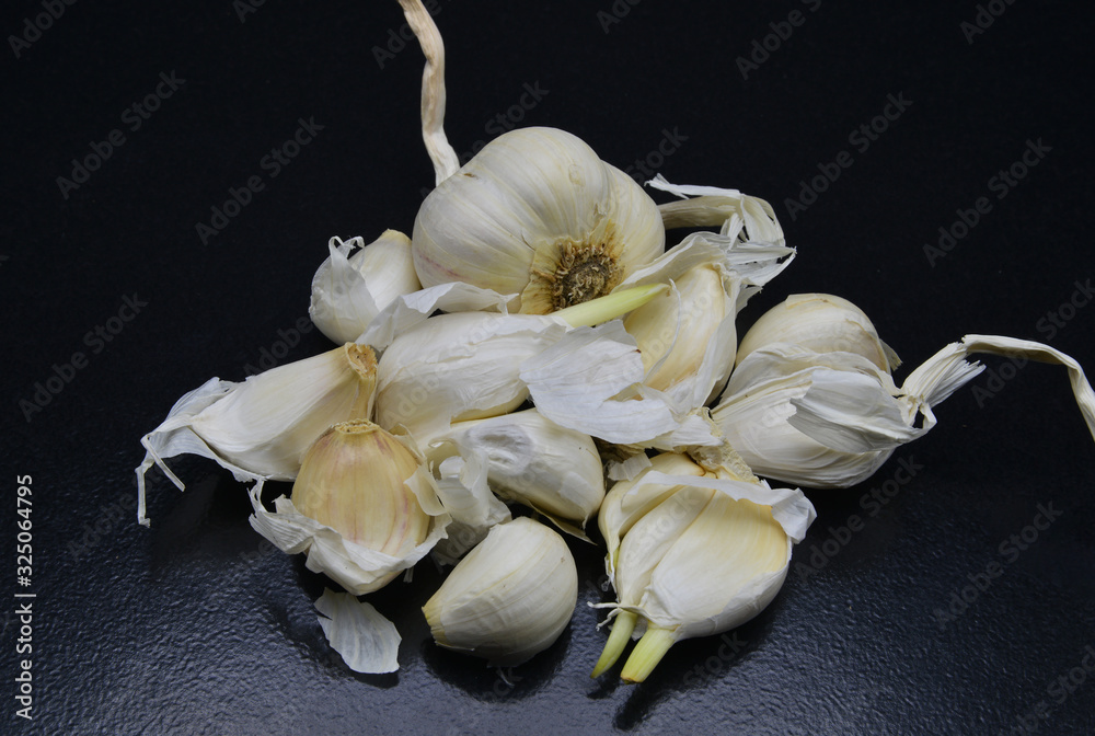 Wall mural organic garlic on black background