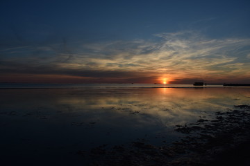 Obraz premium Beautiful orange sunset sky reflection on calm sea