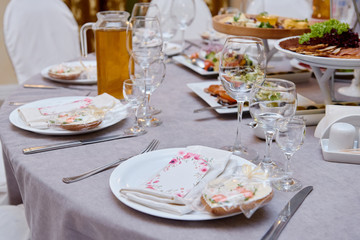 Table setting with sparkling wineglasses and cutlery on table, copy space. Menu mockup, place setting at wedding reception. Table served for wedding banquet in restaurant