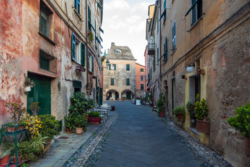 View along narrow street in the medieval village of Finalborgo, Liguria region, Italy