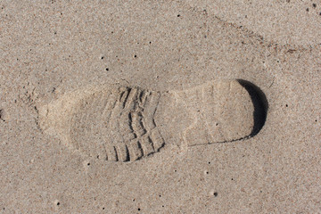 Fototapeta na wymiar Single boot imprint in beach sand