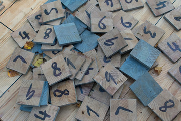 Wooden pieces with numbers on wooden table outdoors.
