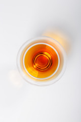 A glass of cognac stands on a white background. The view from the top