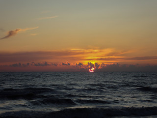 Beautiful orange sunset at sea with waves