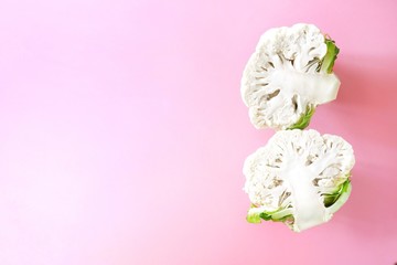 Two half head fresh organic cauliflower on a bright pink background. Minimalistic, natural, lifestyle. Diet concept, healthy food.Creative mocup, Top view, flat lay, copy space for text.