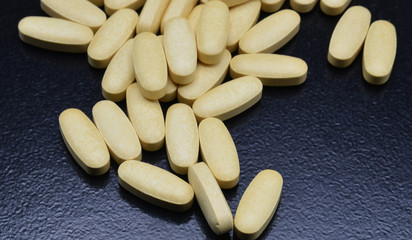 yellow pills on black background