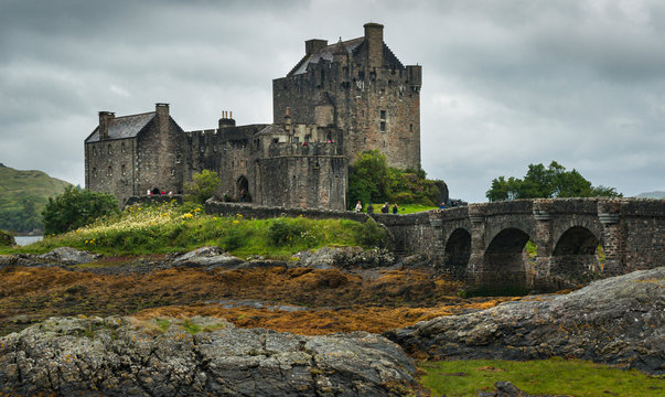 Landscape with the old castle and fortress of Eilean Donan on the shores of Lake Duich in Scotland, with very cloudy sky.