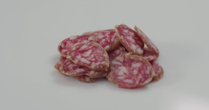Fuet sausage slices rotating on white background