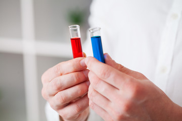 Closeup of doctor holding test tubes with coronavirus assay