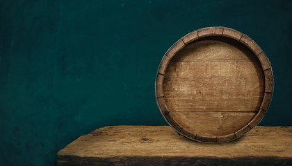 Beautiful wooden barrel and oak worn table of wood on a green wall pattern background for design.