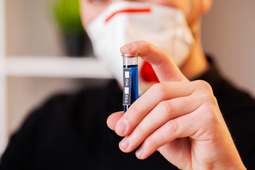 Closeup of doctor holding test tubes with coronavirus assay