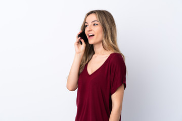 Young woman over isolated white background keeping a conversation with the mobile phone