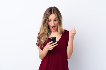 Fototapeta premium Young woman over isolated white background surprised and sending a message