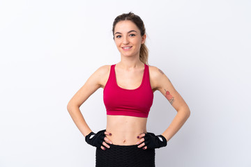 Young sport woman over isolated white background posing with arms at hip and smiling